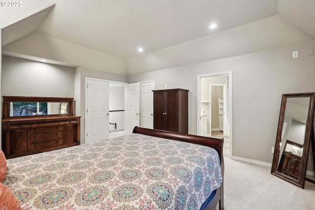 bedroom with lofted ceiling, light colored carpet, baseboards, ensuite bath, and recessed lighting