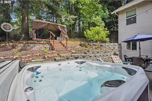 fenced yard featuring a hot tub and a gazebo