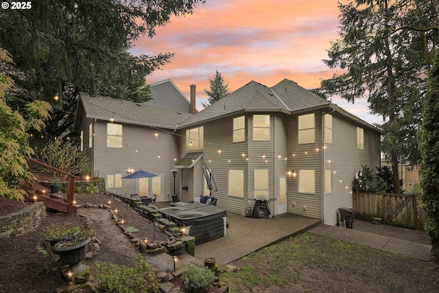 back of property featuring a patio, fence, a hot tub, and roof with shingles