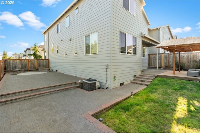 back of property featuring cooling unit, a patio, and a yard