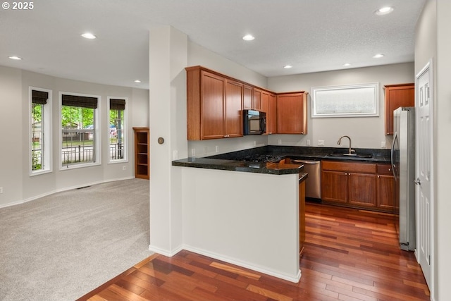 16044 SW Langer Dr, Sherwood, OR 97140 - kitchen featuring appliances with stainless steel finishes, a sink, recessed lighting, dark wood finished floors, and brown cabinetry