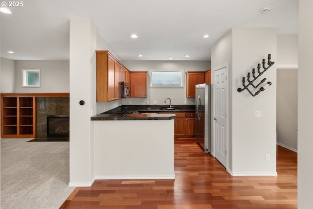 16044 SW Langer Dr, Sherwood, OR 97140 - kitchen with freestanding refrigerator, black microwave, a sink, dark countertops, and light wood-type flooring