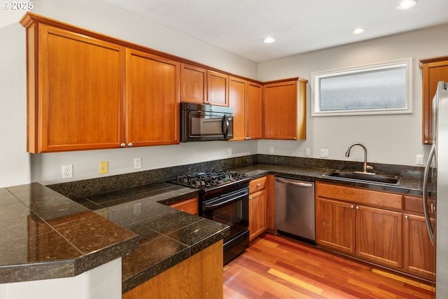 16044 SW Langer Dr, Sherwood, OR 97140 - kitchen with black appliances, a sink, tile countertops, brown cabinets, and recessed lighting