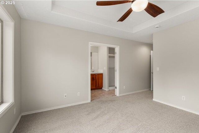 16044 SW Langer Dr, Sherwood, OR 97140 - unfurnished bedroom with light carpet, a tray ceiling, baseboards, and ensuite bathroom
