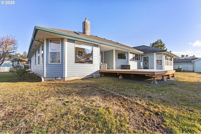 rear view of property featuring a lawn and a deck