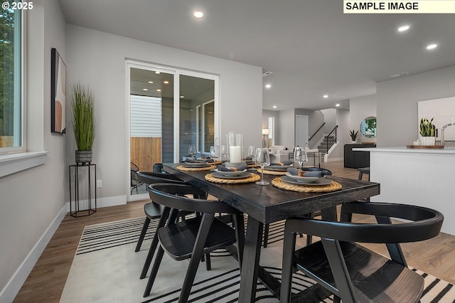 dining space with stairs, recessed lighting, wood finished floors, and baseboards