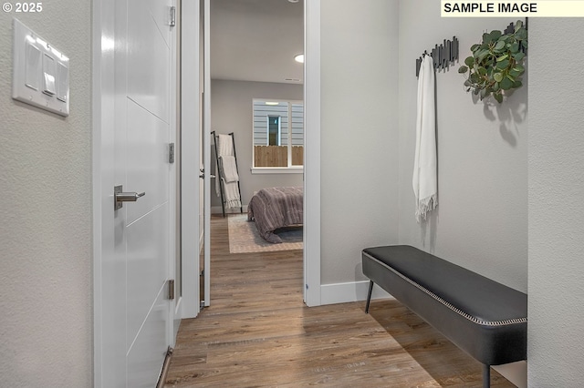 hallway featuring baseboards and wood finished floors