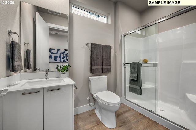 full bathroom featuring visible vents, toilet, a stall shower, wood finished floors, and vanity