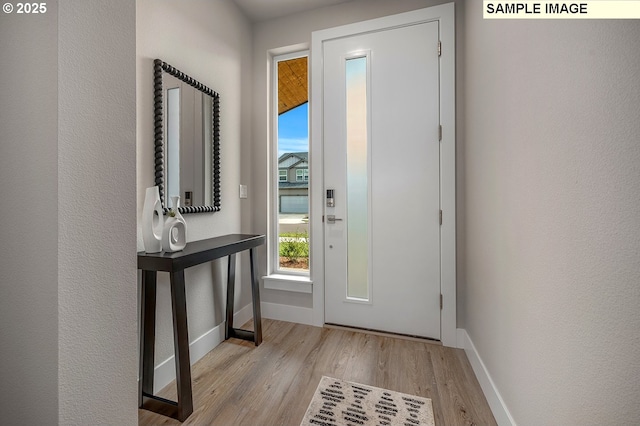 foyer with wood finished floors and baseboards