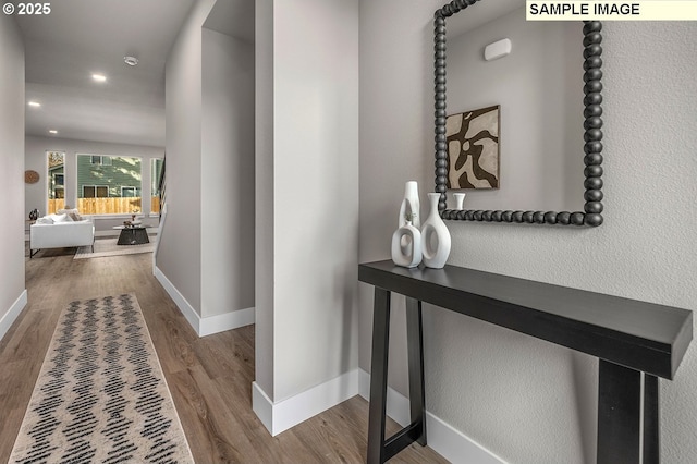 hallway featuring recessed lighting, wood finished floors, and baseboards