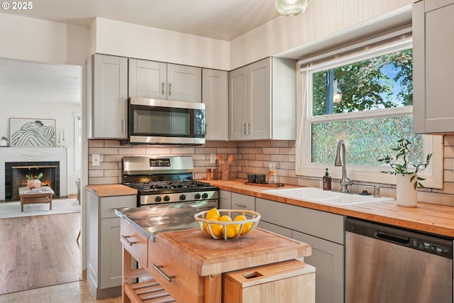 4433 NE 65th Ave, Portland, OR 97218 - kitchen featuring butcher block counters, stainless steel appliances, and backsplash