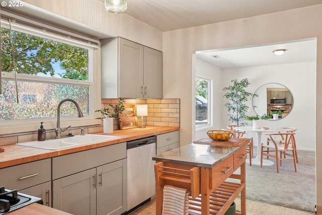 4433 NE 65th Ave, Portland, OR 97218 - kitchen featuring appliances with stainless steel finishes, butcher block countertops, tasteful backsplash, and light colored carpet