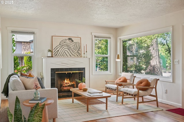 4433 NE 65th Ave, Portland, OR 97218 - living area with wood finished floors, a textured ceiling, and a tiled fireplace