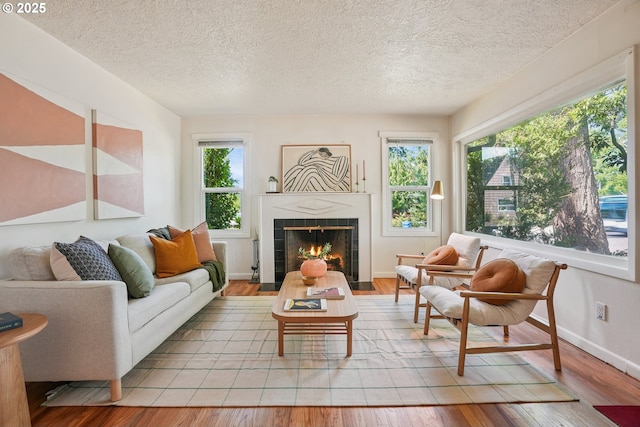 4433 NE 65th Ave, Portland, OR 97218 - living room featuring plenty of natural light, a textured ceiling, wood finished floors, and a fireplace