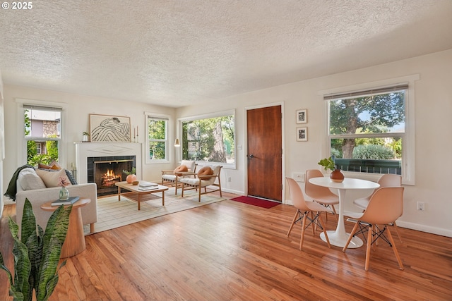 4433 NE 65th Ave, Portland, OR 97218 - living room featuring a textured ceiling, wood finished floors, a tiled fireplace, and plenty of natural light