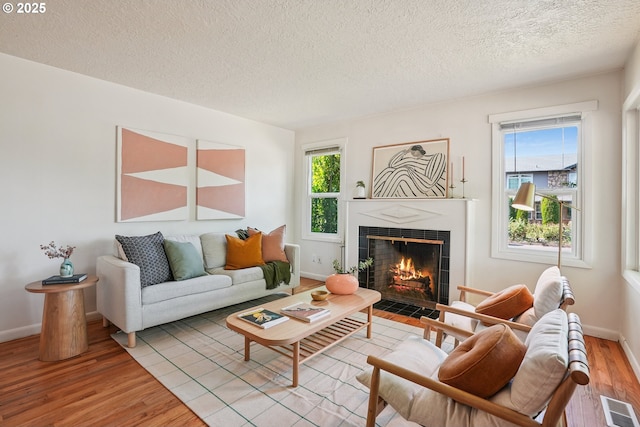4433 NE 65th Ave, Portland, OR 97218 - living room featuring wood finished floors, a fireplace, and a textured ceiling