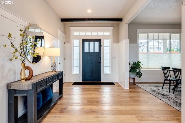 foyer entrance featuring wainscoting and light wood-style flooring