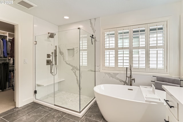 18350 SW Florendo Ln, Beaverton, OR 97007 - bathroom with visible vents, a freestanding bath, a spacious closet, vanity, and a marble finish shower