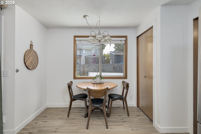 13326 SW Shore Dr, Portland, OR 97223 - dining space with a chandelier, light wood-style floors, and a textured ceiling