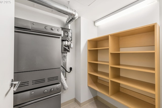 1310 NW Naito Pkwy, Portland, OR 97209 - laundry area featuring stacked washing machine and dryer and baseboards