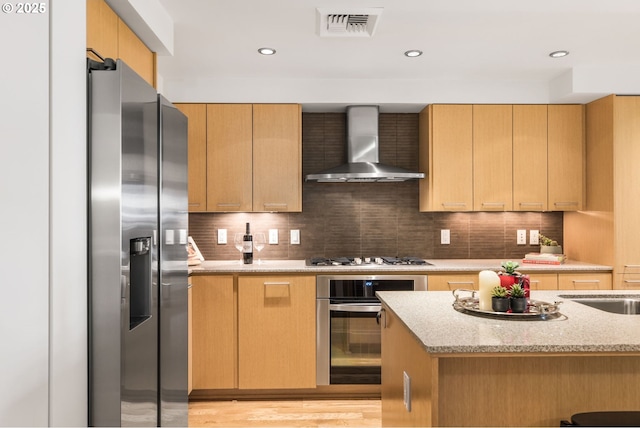 1310 NW Naito Pkwy, Portland, OR 97209 - kitchen with appliances with stainless steel finishes, wall chimney exhaust hood, light stone countertops, tasteful backsplash, and recessed lighting