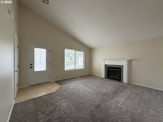 539 NW Blair Loop, Sheridan, OR 97378 - unfurnished living room featuring carpet floors, a fireplace with flush hearth, baseboards, and high vaulted ceiling