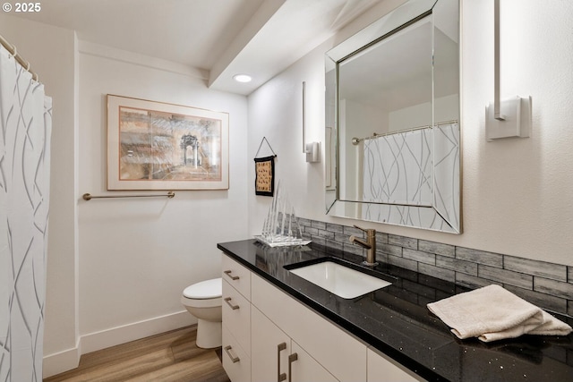 bathroom with hardwood / wood-style flooring, vanity, toilet, and decorative backsplash