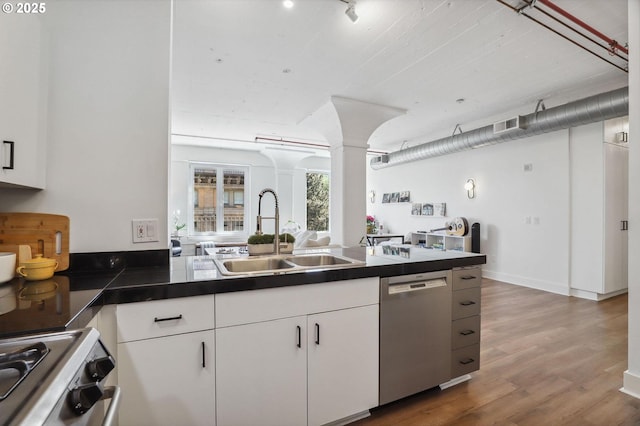 kitchen featuring a sink, ornate columns, gas stove, stainless steel dishwasher, and dark countertops