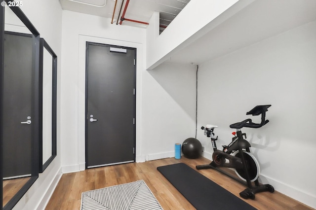 exercise area with baseboards and wood finished floors