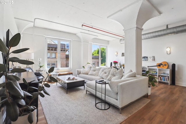 living room with wood finished floors and decorative columns
