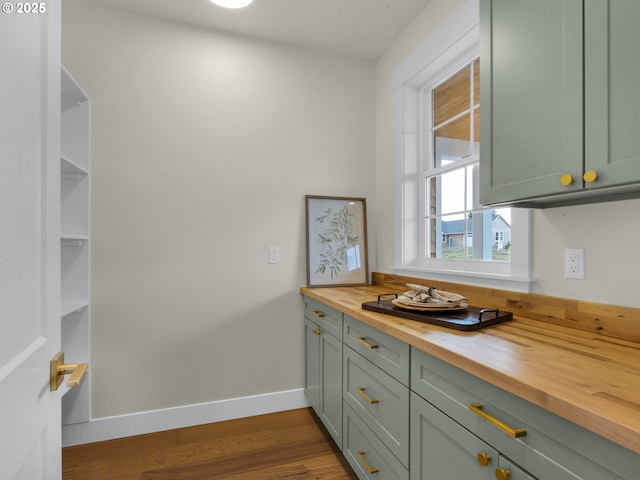 kitchen with wooden counters, dark wood-type flooring, open shelves, and baseboards