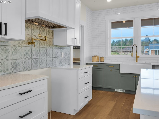 kitchen with white cabinets, light countertops, and a sink