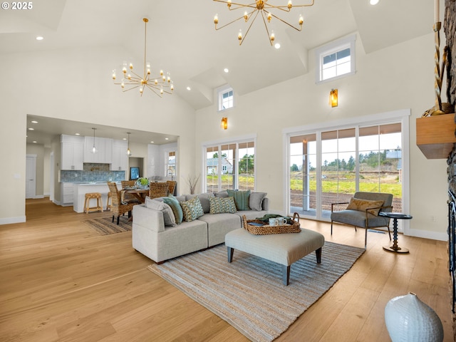 living area with a chandelier, high vaulted ceiling, recessed lighting, baseboards, and light wood-type flooring