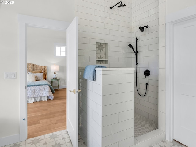 full bathroom featuring walk in shower, baseboards, and ensuite bathroom