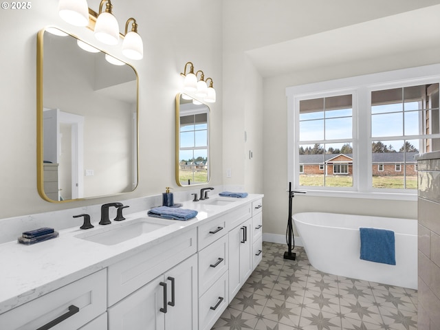 bathroom with plenty of natural light, a freestanding tub, and a sink