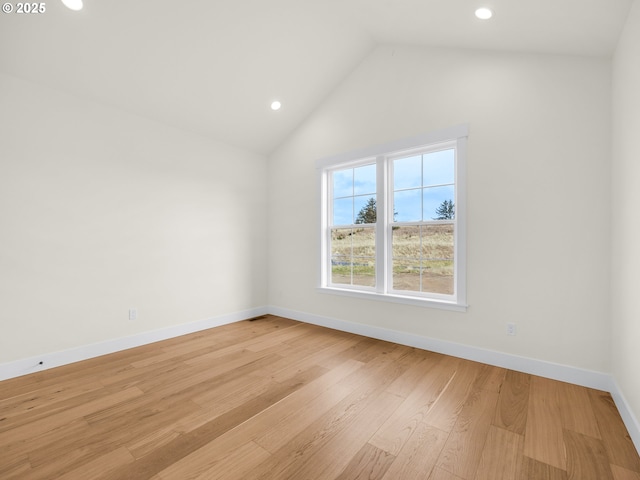 empty room with lofted ceiling, baseboards, light wood finished floors, and recessed lighting