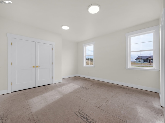 unfurnished bedroom with a closet and baseboards