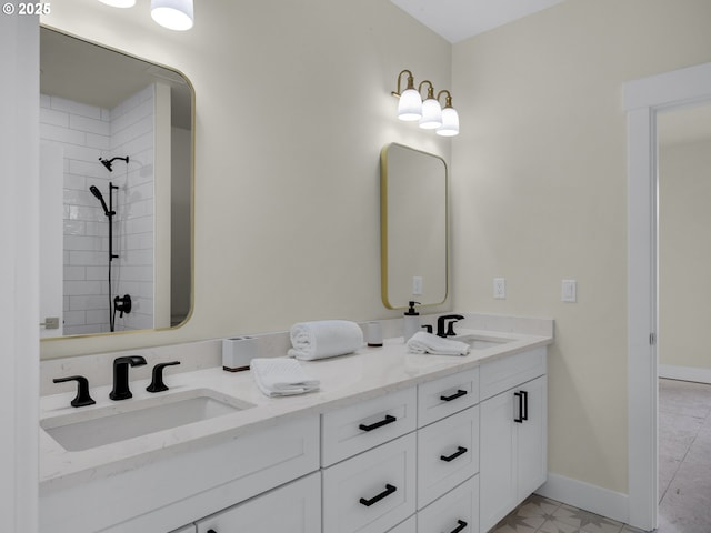 full bath featuring double vanity, a sink, and baseboards