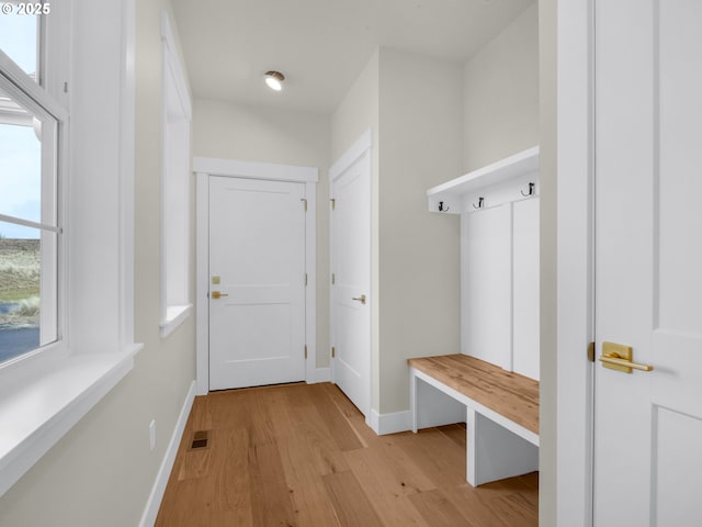 mudroom featuring light wood-style floors, visible vents, and baseboards