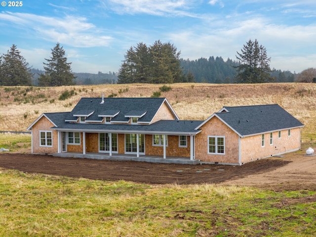 rear view of house with roof with shingles and a patio area