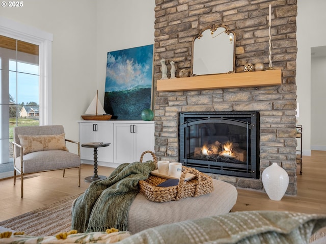 living area featuring baseboards, a fireplace, and light wood-style floors