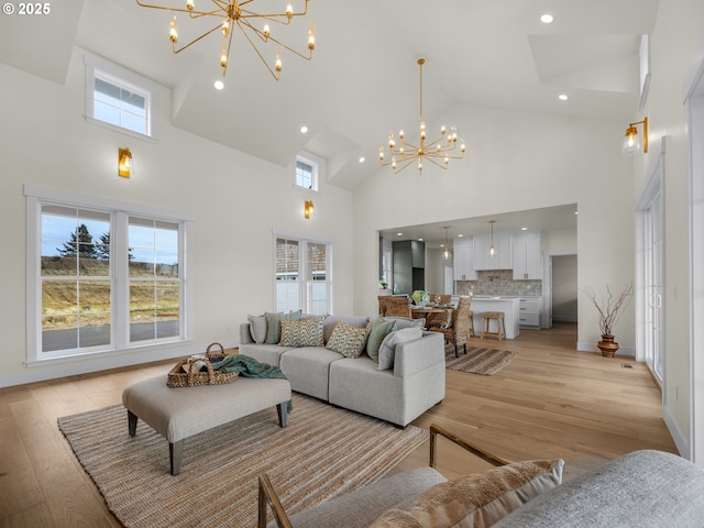 living area with light wood-style floors, recessed lighting, a wealth of natural light, and an inviting chandelier