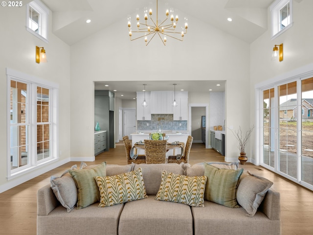 living area featuring light wood-style floors, baseboards, high vaulted ceiling, and recessed lighting