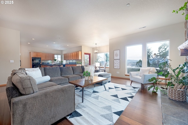 living room with light hardwood / wood-style floors and a textured ceiling