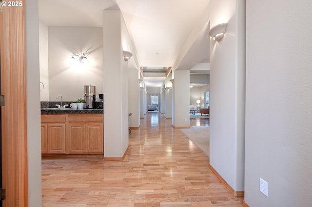 hallway with sink and light wood-type flooring