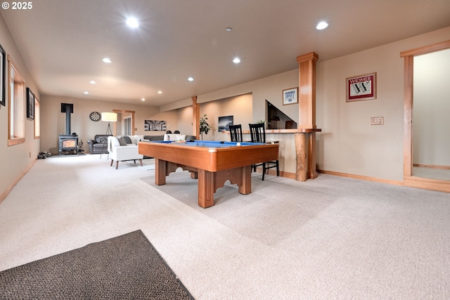 game room featuring light carpet, billiards, and a wood stove