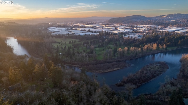 aerial view at dusk featuring a water and mountain view