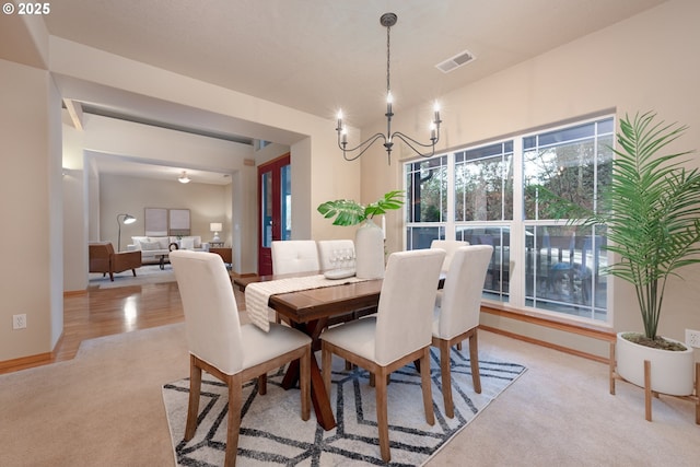 carpeted dining space featuring an inviting chandelier