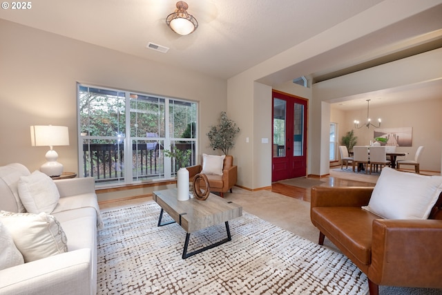 living room featuring light carpet and a notable chandelier