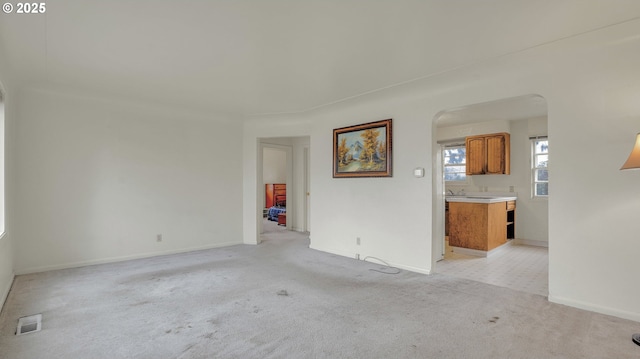 unfurnished living room with light colored carpet